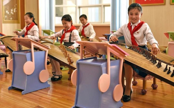 Các em học sinh nữ đang học chơi một loại nhạc cụ truyền thống của Triều Tiên.