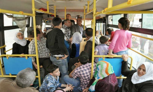 Cảnh tượng đông đúc trên xe buýt tại Syria. Mọi người hào hứng nói chuyện với nhau.