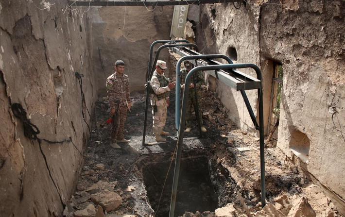 Binh sĩ Iraq kiểm tra một đường hầm do các chiến binh IS xây dựng trong một tòa nhà bị phá hủy sau cuộc không kích tại làng Mahana, cách thành phố Mosul khoảng 60 km về phía nam.