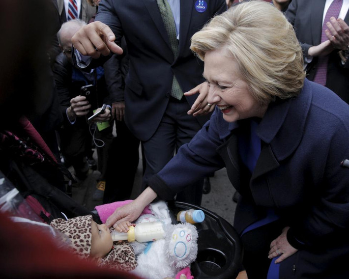 Cựu Ngoại trưởng Mỹ Clinton cười tươi khi gặp một em bé sơ sinh trên đường phố ở Bronx hôm 7/4.