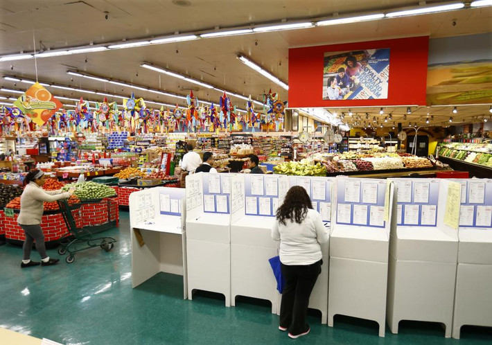 Người phụ nữ đang bỏ phiếu tại một cửa hàng tạp hoá ở National City, California ngày 4/11/2014.
