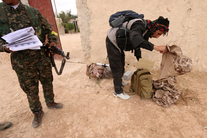 Các chiến binh SDF thu thập đồ đạc của phiến quân IS ở phía nam Manbij, Syria, ngày 31/5. Ảnh cắt từ video ngày 6/6 cho thấy, các gia đình Iraq vượt sông Euphrates để trốn thoát khỏi thành trì Fallujah của IS.