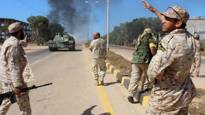 Binh sĩ thuộc lực lượng Libya đi bộ dọc theo một con đường trong cuộc tấn công ở khu vực phía đông và nam thành phố Sirte ngày 9/6.