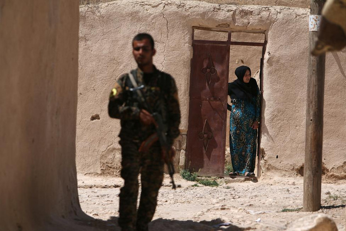 Một chiến binh thuộc Các lực lượng Dân chủ Syria (SDF) đứng gác tại một ngôi làng ở vùng ngoại ô thành phố Manbij ngày 8/6, sau khi họ giành lại quyền kiểm soát ngôi làng này từ tay phiến quân IS.
