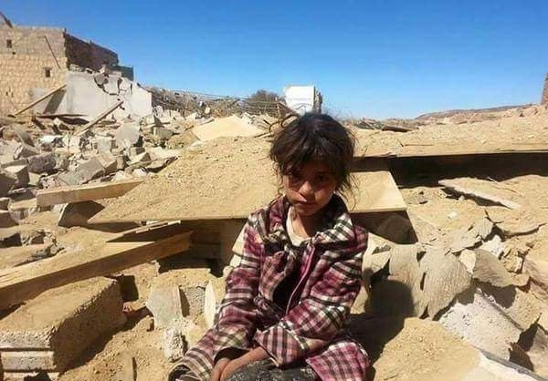 Bé gái Yemen ngồi giữa đống đổ nát.