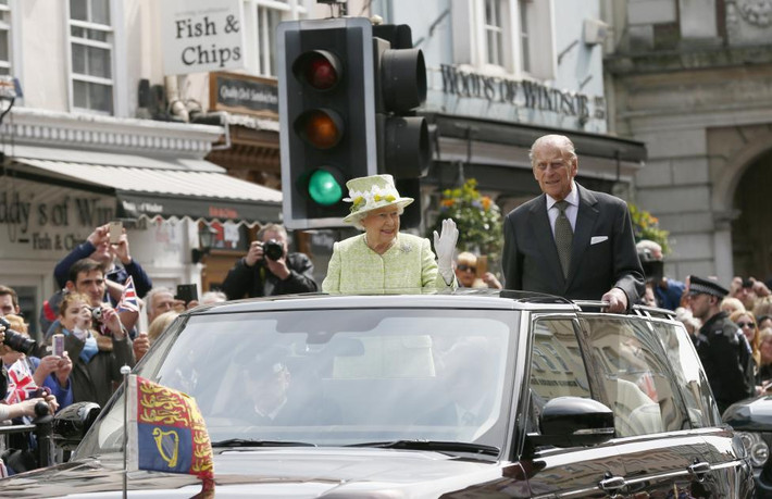 Nữ hoàng Anh Elizabeth II và Hoàng tế Philip vẫy tay chào mọi người khi đi qua đường phố ở Windsor hôm 21/4.