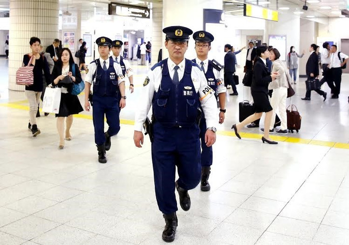 Cảnh sát Nhật Bản trong trang phục sơ mi trắng, quần âu, áo gile, tuần tra nhà ga Tokyo trước thềm Hội nghị Thượng đỉnh G7 cuối tháng 5. Ảnh: Reuters.