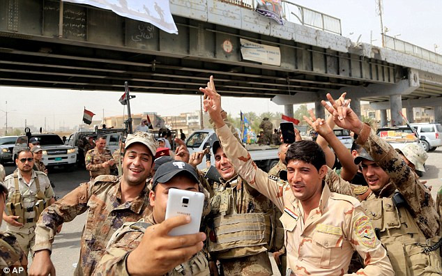 Lực lượng an ninh Iraq chụp ảnh ăn mừng chiến thắng tại Fallujah hôm 28/6 sau khi giành lại quyền kiểm soát thành phố này khỏi tay nhóm IS.