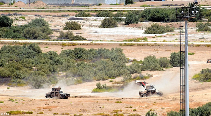 Hai chiếc xe quân sự hạng nặng Humvee tiến về mặt trận ở vùng ngoại ô Fallujah đánh IS.