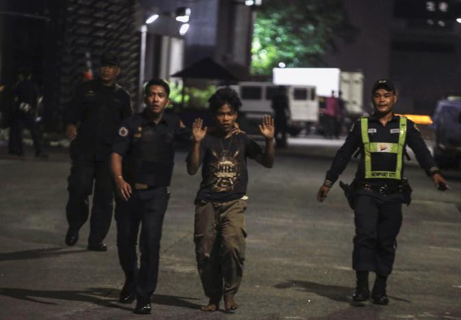 Cảnh sát Philippines đưa một nhân viên khách sạn ra ngoài. Ảnh: Reuters.