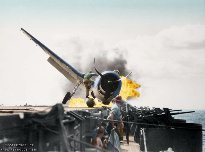 Trung úy Walter Lewis Chewning leo lên thùng nhiên liệu của chiếc máy bay F6F-3 Hellcat đang bốc cháy để giải cứu phi công ngày 10/11/1943. Ảnh: MT.