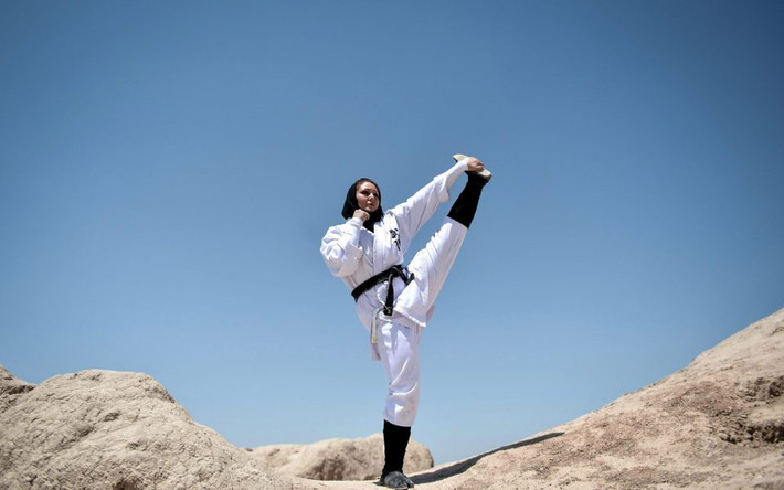 Nữ binh ninja trong bộ võ phục màu trắng thể hiện một động tác trên sa mạc. Ảnh: The Sun.