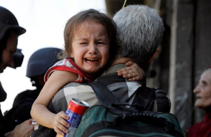 Bé gái khóc vì sợ hãi ở Tây Mosul ngày 23/6. Ảnh: Reuters.