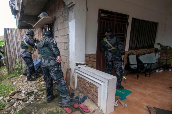 Các binh sĩ Philippines lục soát một ngôi nhà trong thành phố.