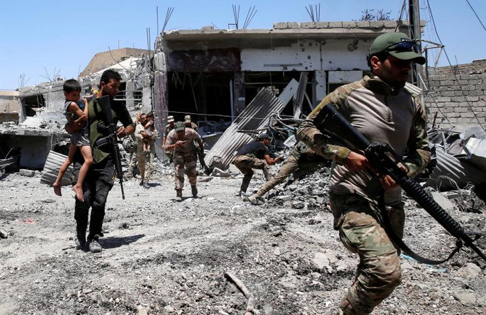 Binh sĩ Iraq bế các em nhỏ đến nơi an toàn trong thành phố Mosul. Các cuộc giao tranh giữa lực lượng Iraq và phiến quân IS ở Tây Mosul vẫn diễn ra ác liệt. (Nguồn ảnh: Reuters)