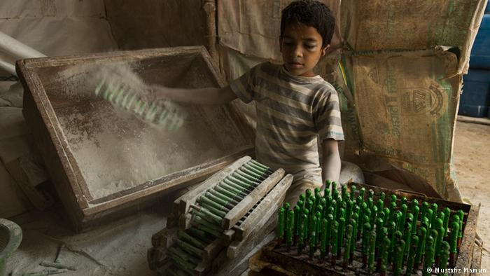 Vì gia đình quá nghèo, nhiều em nhỏ ở Bangladesh đã phải làm việc trong các nhà máy để kiếm tiền. Những đứa trẻ thường phải làm công việc nguy hiểm với mức lương bèo bọt. Ảnh: Một lao động trẻ em Bangladesh chỉ khoảng 10 tuổi làm việc trong nhà máy ở Kamrangi Char, ngoại ô thủ đô Dhaka. Ảnh: DW.