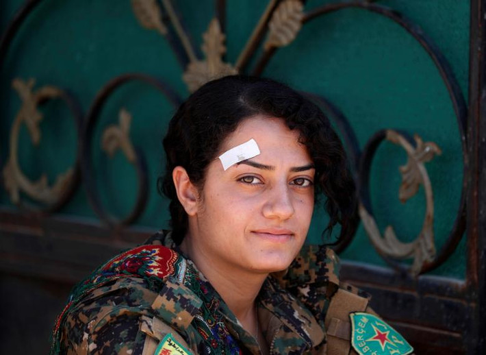 Nữ chiến binh người Kurd ngồi nghỉ ở Raqqa hôm 15/6.