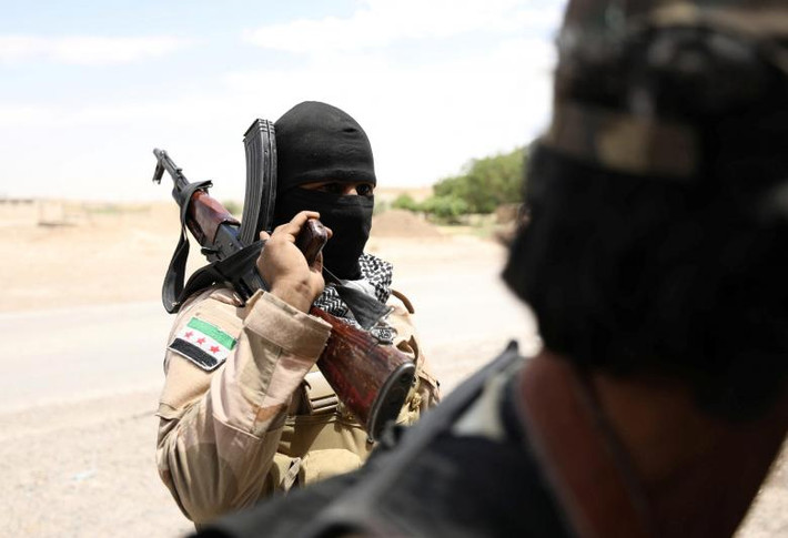Một chiến binh SDF mang theo vũ khí gần thành phố Raqqa hôm 14/6.