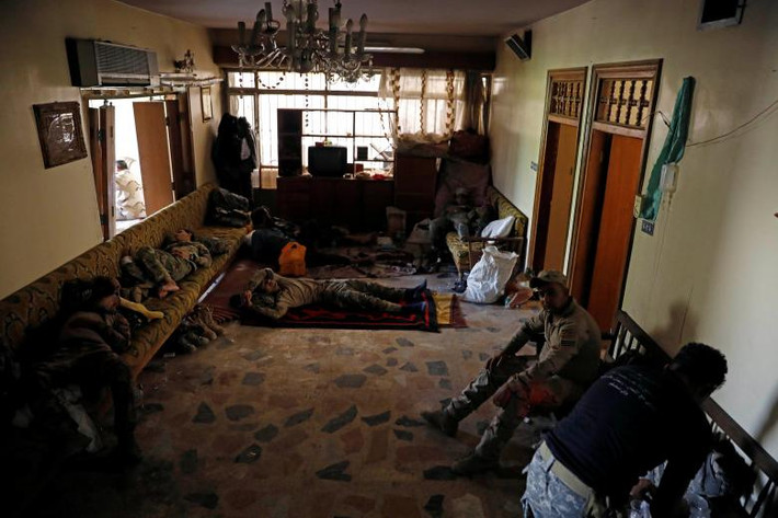 Các binh sĩ Iraq ngồi nghỉ trong một ngôi nhà ở Tây Mosul.