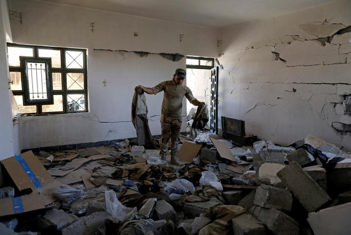 Một binh sĩ Iraq đứng trong căn nhà bỏ hoang từng được nhóm khủng bố IS sử dụng ở Tây Mosul.