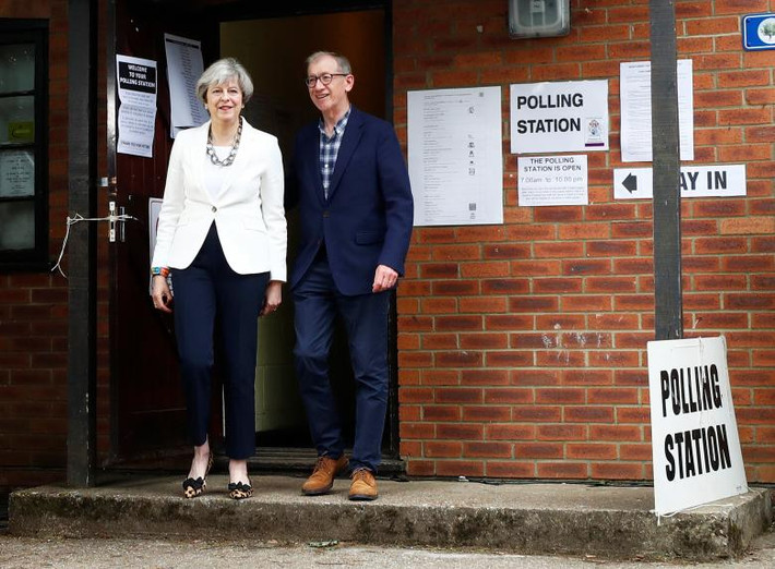 Thủ tướng Anh Theresa May cùng chồng, Philip, rời khỏi một điểm bỏ phiếu ở Sonning.