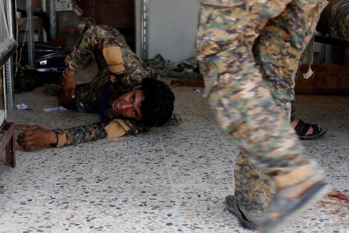 Chiến binh SDF bị thương nằm trên sàn nhà trong bệnh viện dã chiến ở Raqqa hôm 28/6.