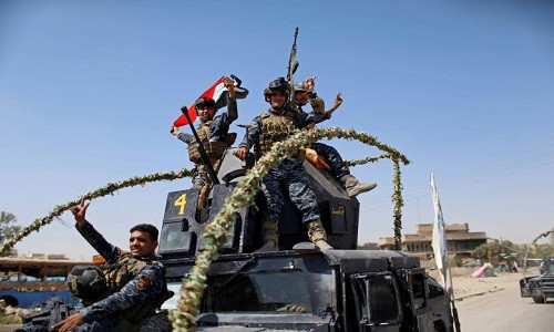 Cảnh sát Liên bang Iraq giơ tay biểu tượng chiến thắng khi trở về từ tiền tuyến ở Thành cổ Mosul.