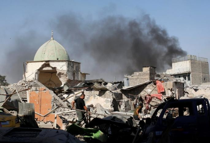 Theo Reuters, ngày 29/6, quân đội Iraq đã giành lại quyền kiểm soát phần còn lại của nhà thờ Hồi giáo al-Nuri 850 tuổi ở khu Thành cổ Mosul. Ảnh: Một thành viên của lực lượng chống khủng bố Iraq đi qua đống đổ nát ở nhà thờ al-Nuri hôm 29/6.