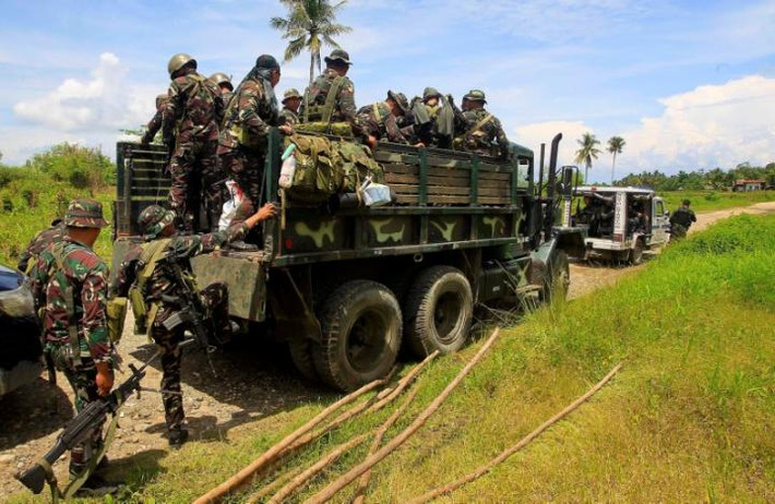 Binh sĩ và cảnh sát Philippines lên xe quân sự ở thị trấn Pigcawayan, tỉnh Bắc Cotabato, miền Nam Philippines. Sáng ngày 21/6, các tay súng được cho là thuộc nhóm Chiến binh Tự do Hồi giáo Bangsamoro (BIFF) đã tấn công vào một trường học gần thị trấn Pigcawayan và bắt giữ con tin.