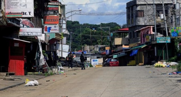 Cảnh sát Philippines tuần tra dọc một con đường chính ở Marawi hôm 22/6.