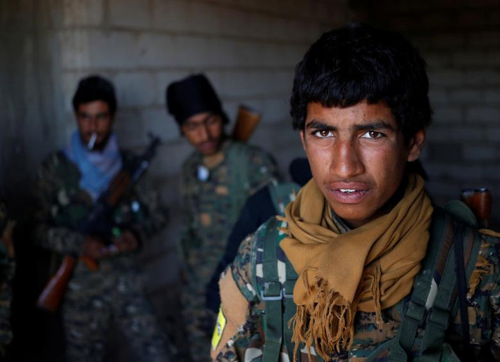 Lực lượng YPG đứng trong một ngôi nhà ở Raqqa ngày 21/6.