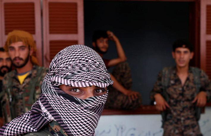 Chiến binh người Kurd tập trung bên ngoài một ngôi nhà ở tỉnh Raqqa ngày 21/6. Thành phố Raqqa được coi là “thủ phủ” của phiến quân IS tại Syria trong vài năm qua.