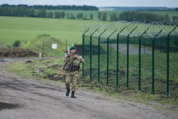 Một binh sĩ tuần tra cạnh hàng rào biên giới Nga-Ukraine. (Nguồn: ER)