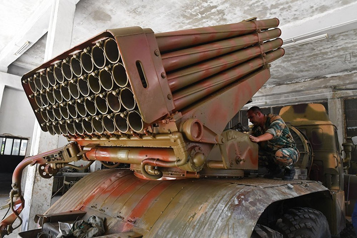 Người thợ đang sửa chữa pháo phản lực phóng loạt BM-21 Grad. Ảnh: Sputnik.