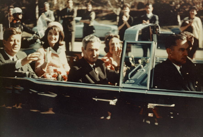 Ảnh chụp Tổng thống Kennedy và Đệ nhất phu nhân ngồi trên chiếc limousine vẫy chào mọi người không lâu trước khi vụ ám sát xảy ra. Ảnh: ATI.