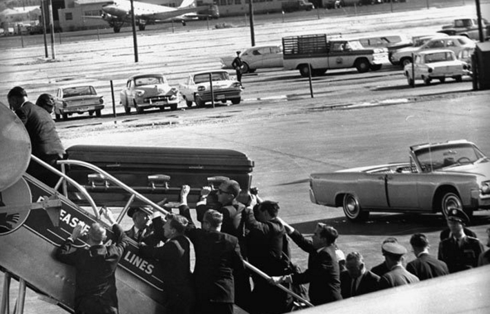 Các nhân viên mật vụ Mỹ đưa linh cữu của Tổng thống John F.Kennedy lên chiếc Không lực Một tại sân bay Love Field. Ảnh: ATI.