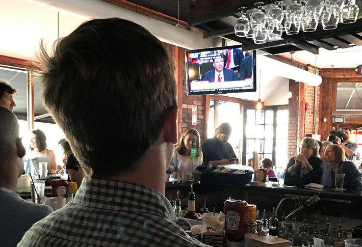Mọi người theo dõi phiên điều trần của ông Comey qua ti vi tại quán rượu Shaw’s Tavern ngày 8/6. Ảnh: Reuters.