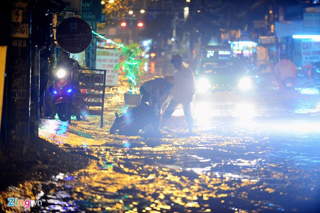 Một người dân bị ngã khi đi qua đoạn đường ngập nước.