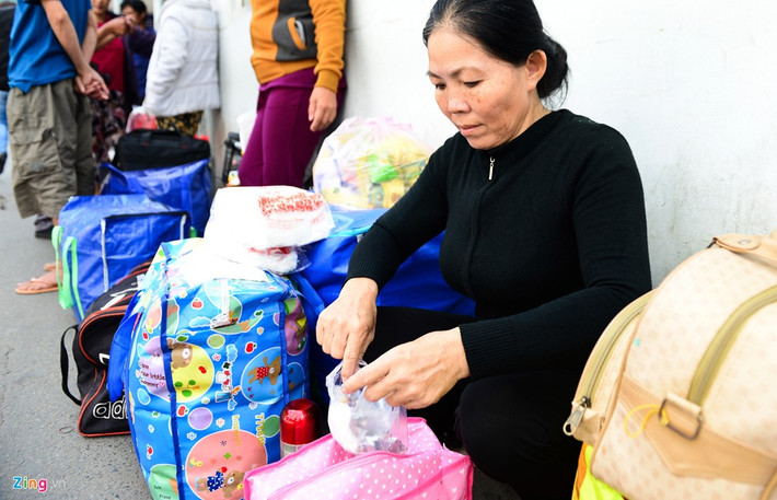 Bà Phạm Thị Giàu (quê An Giang) tranh thủ uống thuốc trước khi lên xe về quê ăn Tết. Bà cho biết mấy ngày nay được các nhà hảo tâm vào tận phòng bệnh cho tiền, cho quà khiến bà rất xúc động.