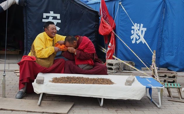 Hai nhà sư trêu đùa nhau khi bán đông trùng hạ thảo bên ngoài lều tạm của họ.