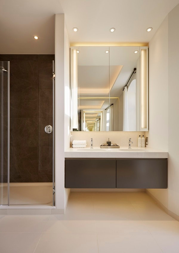 Phòng tắm được bố trí đơn giản nhưng đủ để mọi người cảm thấy thoải mái nhất khi sử dụng. Hệ thống đèn hắt trần được sử dụng một cách triệt để cùng ánh sáng vàng trắng tạo nên sự sang trọng và ấm cúng cho căn phòng. Hai khu vực tắm táp và rửa mặt được tách biệt. Thêm pha gương gắn toàn bộ bức tường nhỏ vừa tăng ánh sáng và hoàn thiện vẻ đẹp hiện đại, tinh tế cho không gian thư giãn.