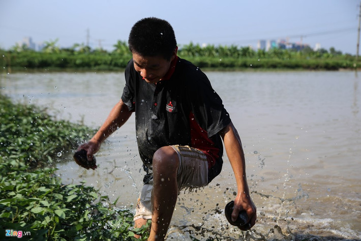 Em Hoàng mò trai ốc cho mẹ. Mỗi ngày em 2 buổi mò tôm bắt ốc, nhiều thì để bán, ít thì để ăn.