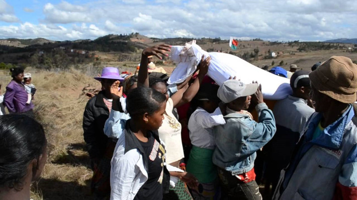 Famadihana là kiểu mai táng kỳ lạ của người Malagasy ở Madagascar. 7 năm một lần, người Malagasy lại đào mộ, mang bộ xương của người đã khuất lên và cuốn vào một tấm vải mới. Sau đó, họ vác bộ xương đi vòng quanh làng, vừa đi vừa nhảy múa, ca hát và chơi nhạc. Đây là cách để người dân Malagasy tưởng nhớ đến những người đã khuất. Ảnh: Padri Letah/Youtube.