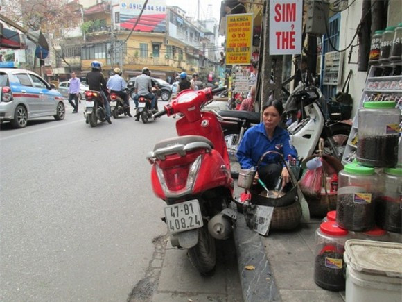 Người bán hàng trên phố cổ "tự nhiên" rán bánh cho khách trên vỉa hè.