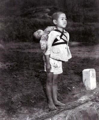 2. Hai anh em ở thành phố Nagasaki sau vụ tập kích trên không Đứa trẻ đã chết trên lưng người anh, trong khi người anh đứng lặng người, mím chặt môi và không hề khóc trước sự ra đi của em mình. Tuy “cả thế giới” của cậu đã sụp đổ nhưng cậu bé đã nuốt hết nỗi đau ấy vào lòng, để đường hoàng mà tiễn đưa em mình về nơi an nghỉ cuối cùng.