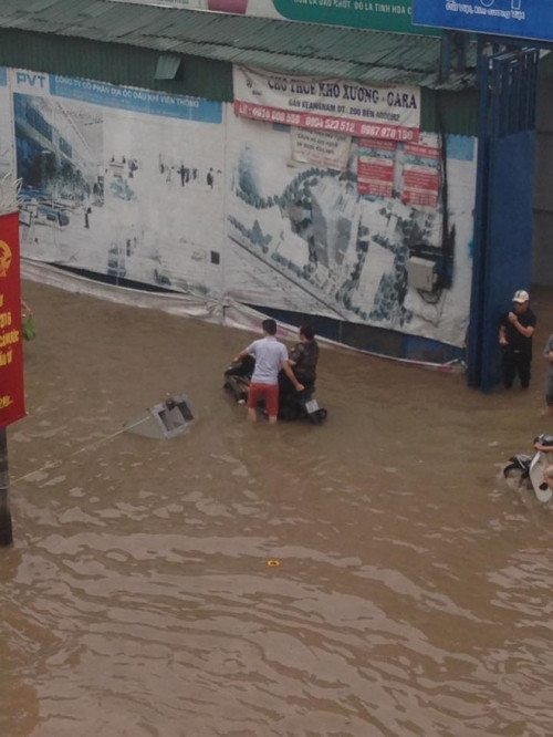 Khoảnh khắc chàng trai dắt xe cho mẹ ngồi trên yên qua chỗ ngập nước cũng lay động triệu trái tim về tình mẫu tử thiêng liêng. (Ảnh: Duy Khánh).
