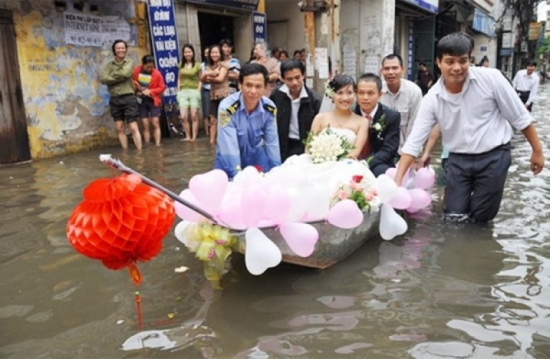 Một đám cưới khác trong trận lũ lụt năm 2008 ở Hà Nội, cô dâu chú rể di chuyển bằng thuyền giữa phố ngập nước.
