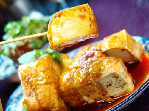 Đậu phụ thối. Có tên gọi không mấy thơm tho nhưng đậu phụ thối chính là một đại diện của nền ẩm thực đường phố Trung Hoa. Món ăn rùng rợn này được làm từ những miếng đậu phụ lên men lâu ngày, sẽ hấp dẫn hơn cả nếu tẩm thêm vị cay của ớt nướng hay bột cà ri thơm nồng. Tuy có mùi vị thum thủm không mấy dễ chị,u nhưng nếu đã trót lọt được miếng đầu tiên thì có thể bạn sẽ không ngừng đũa đấy, vì món ăn này có sức hấp dẫn rất kỳ lạ.