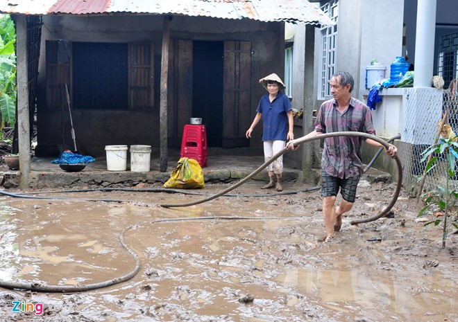Từ sáng sớm đến chiều tối 14/12, vợ chồng bà Tô Thị Gái vẫn chưa thể dọn dẹp hết đống bùn đất dày đặc từ trong nhà đến ngoài sân do lũ quét gây ra.