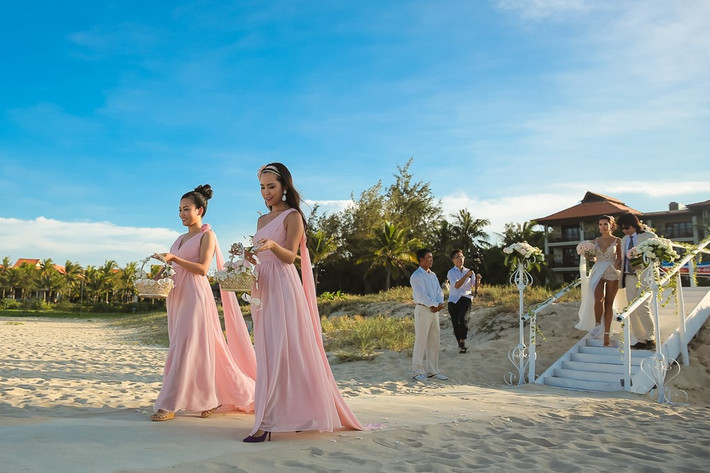 Bố Hà Anh - họa sĩ Huy Vũ - nắm tay con gái tiến ra bãi biển, nơi chú rể Olly Dowden và 60 khách mời chờ đợi.